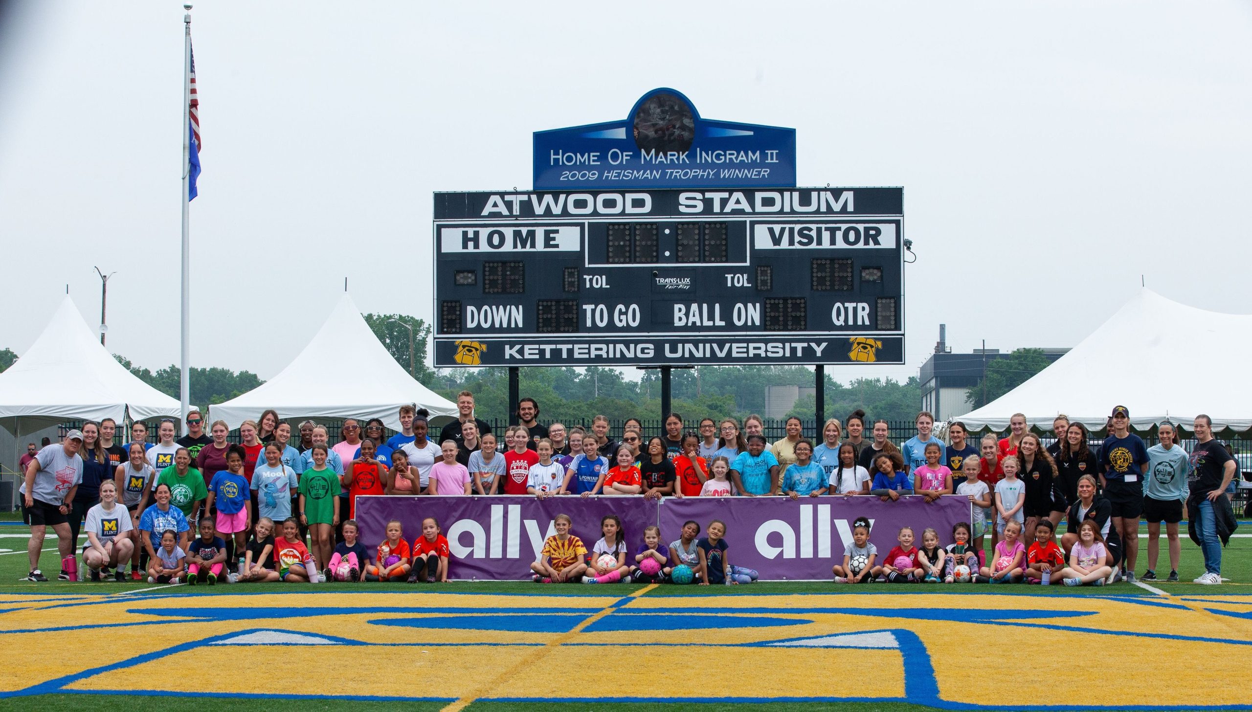 Participants and coaches pose for a group photo during the 'Empowering Women in Soccer Flint Style!' clinic at Atwood Stadium on Saturday, June 8, 2025.