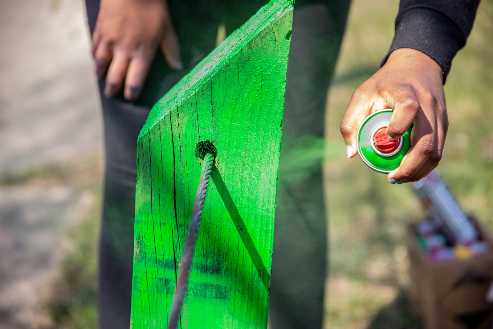 Community members repaint playground fencing.