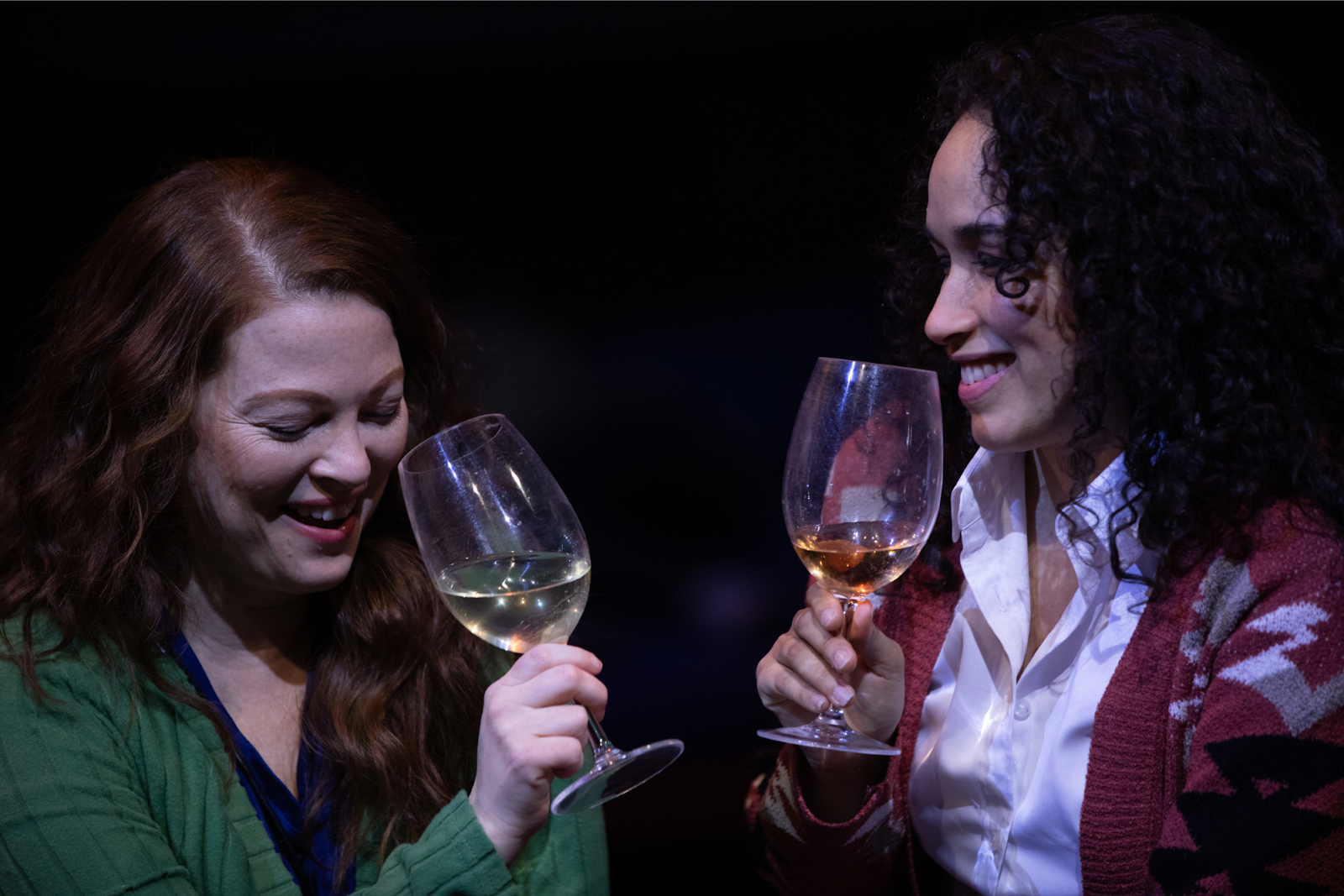 Diane and Reina are all smiles while sharing a glass of wine in the play 'A Driving Beat.' 