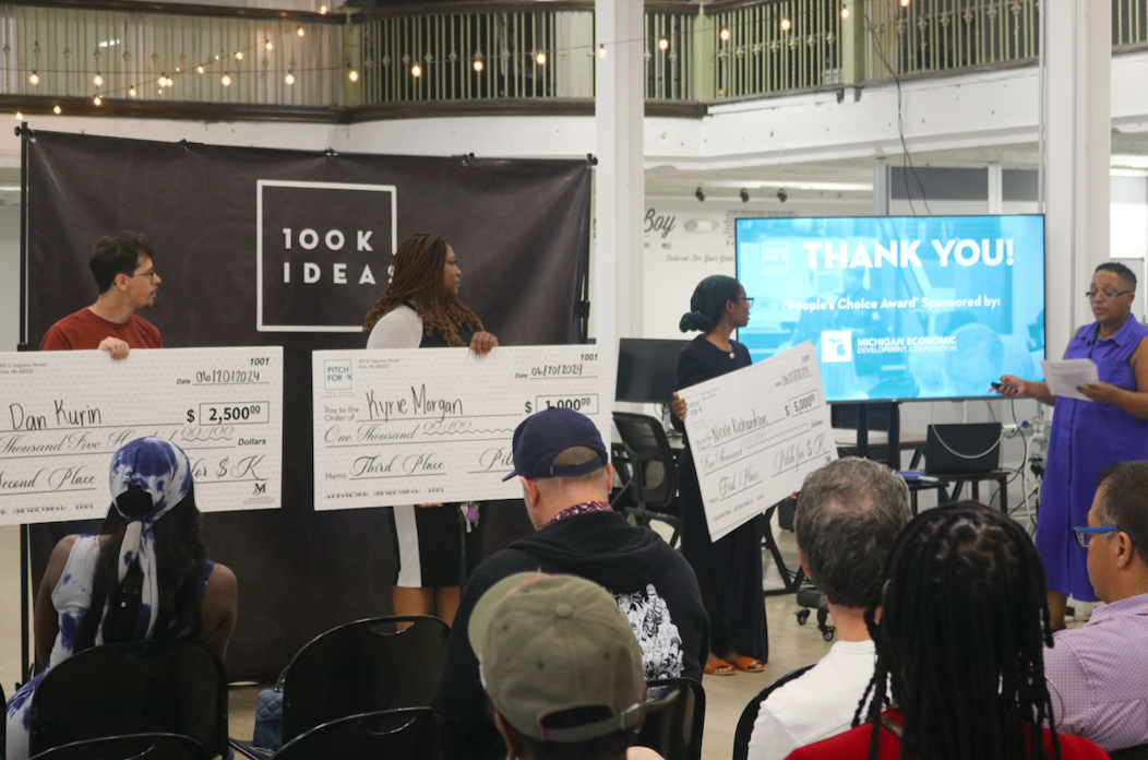 Participants receive their prizes at a previous 'Pitch for $K' competition. 