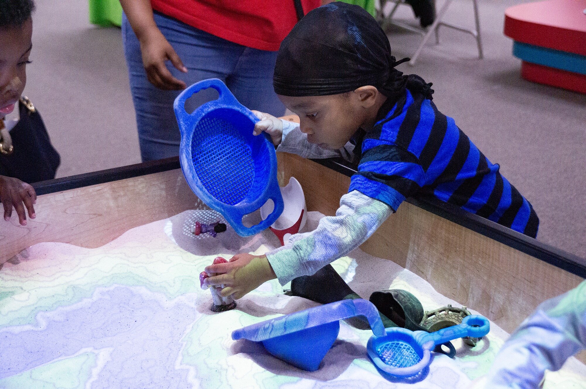 A young boy plays in the virtual sandbox at the Flint Children’s Museum.