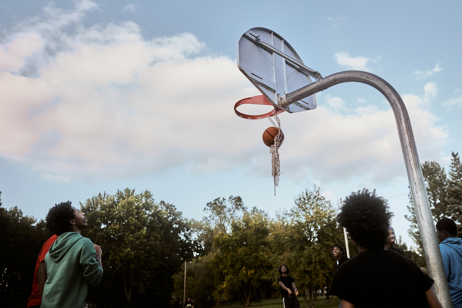 A torn net doesn't stop teens from shooting hoops at Sarvis Park on Sept. 28, 2024. (Bryce Mata | Flintside.com)