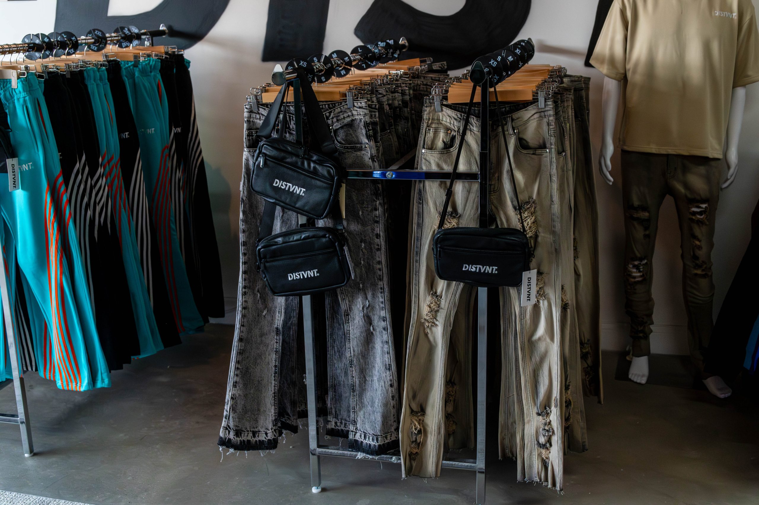 A rack of DISTVNT-brand jeans and purses was on display during the grand opening of DISTVNT's storefront on Saturday, September 7, 2024. (Ray Gray | Flintside.com)