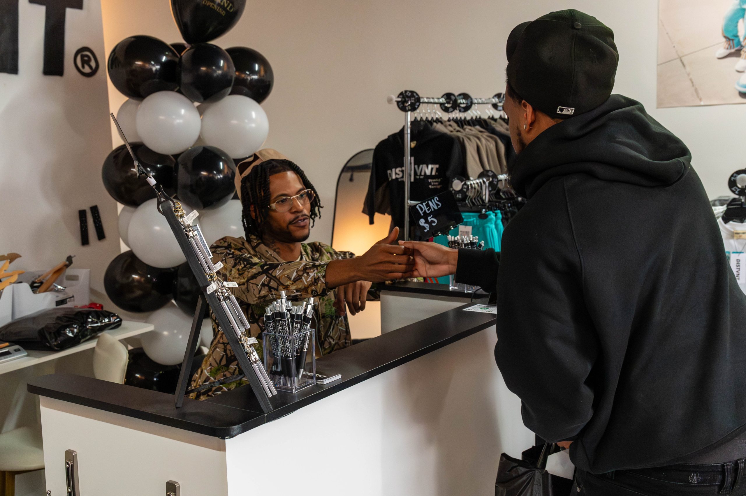 Jock Giles closes a sale with a long-time customer during the grand opening of DISTVNT's storefront on Saturday, September 7, 2024. (Ray Gray | Flintside.com)