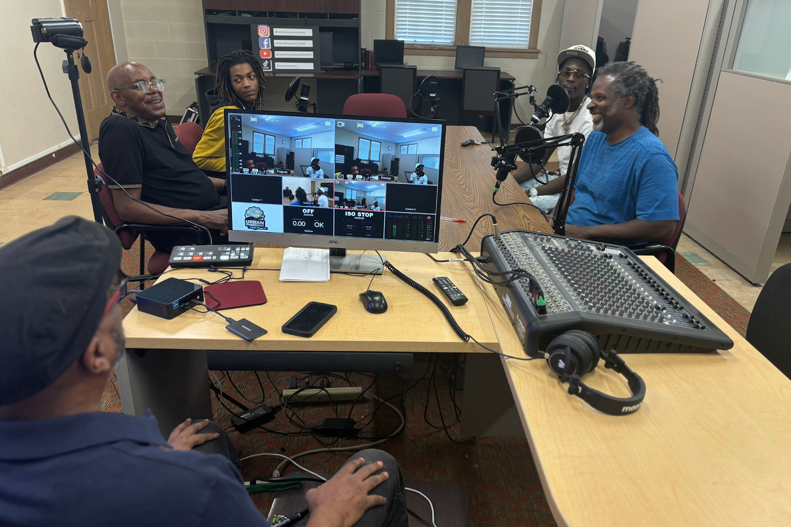 The Urban Renaissance Center members and local artists sit together in the podcast room on Aug. 8, 2024. (Jerimiah Whitehead | Flintside.com)