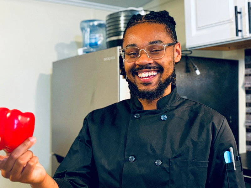 Flint native and chef Terrail Jones II is all smiles while holding a red bell pepper on July 15, 2024.