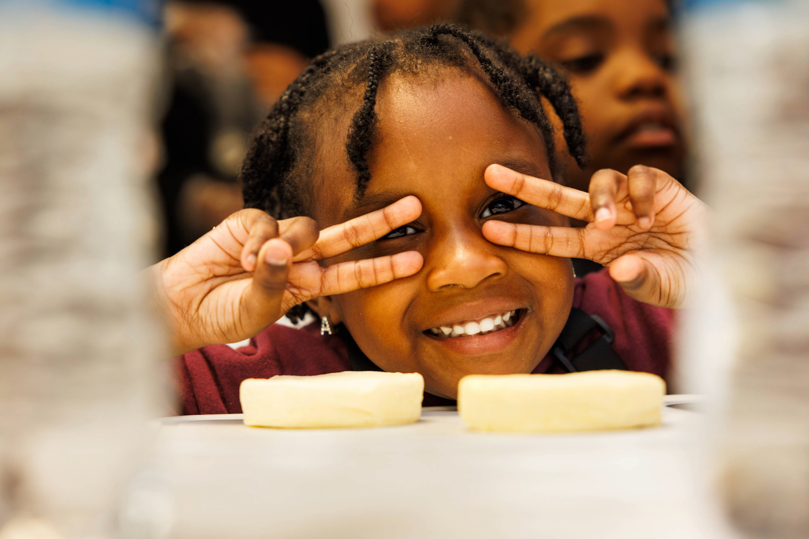 The young girls were all smiles and full of energy as they made donuts from fried biscuits during Mission Possible's NourisHER class on May 11, 2024. (Bryce Mata | Flintside.com)