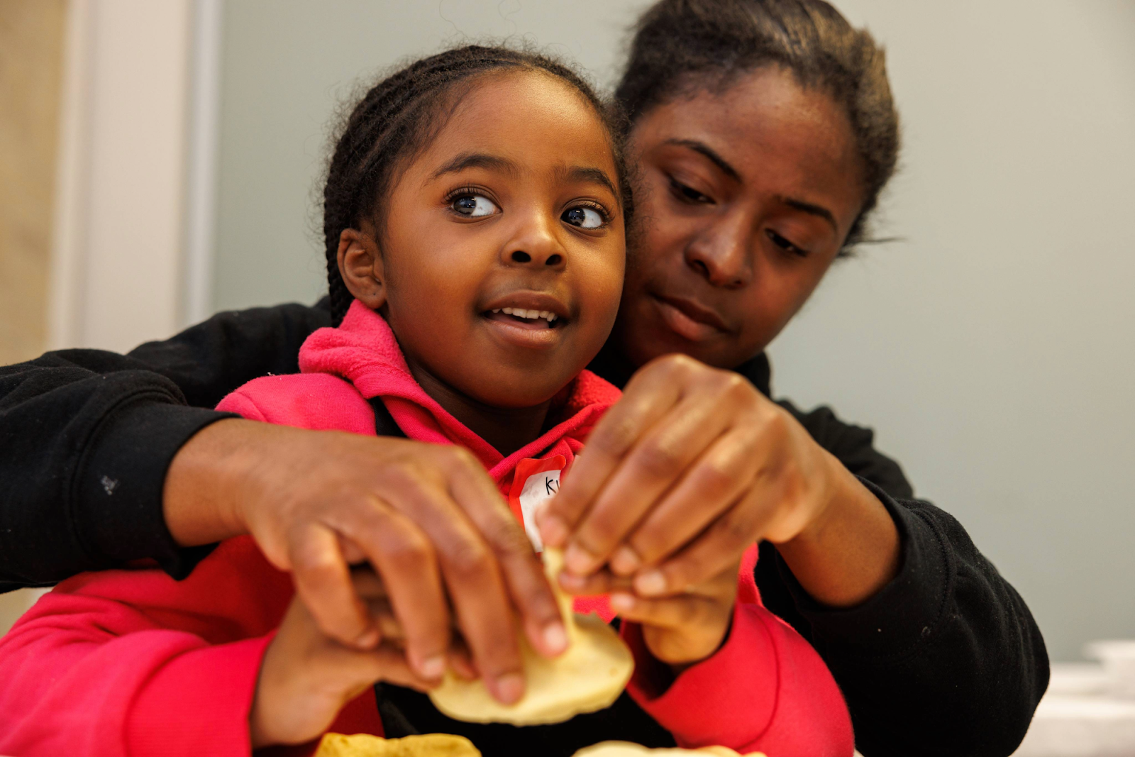 A mother-daughter duo prepares to make fried donuts during Mission Possible's NourisHER class on May 11, 2024. (Bryce Mata | Flintside.com)