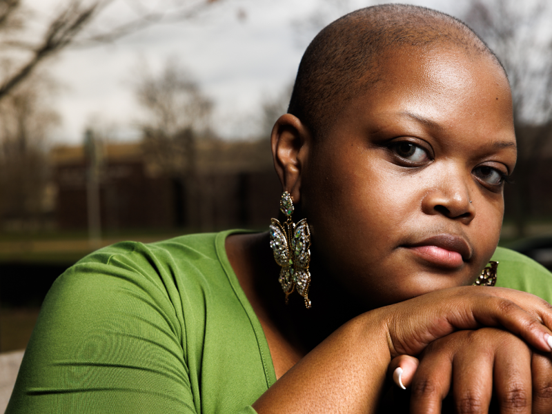 Pageant winner, poet, painter, and queer creative artist AshleyCae Lee poses dignified at the Flint Public Library on March 26, 2024.