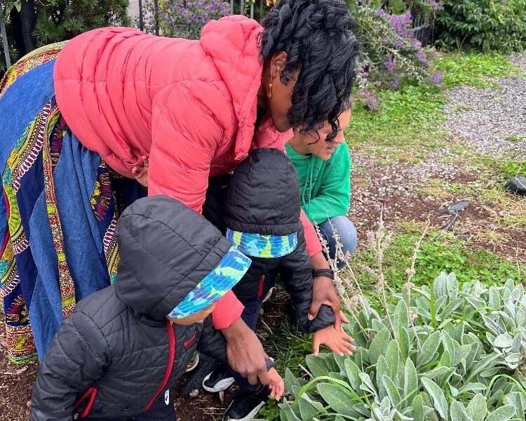 Lorna Parks, owner of House of Joy Childcare in Detroit, takes two of her children to visit the Keep Growing Detroit Garden.
