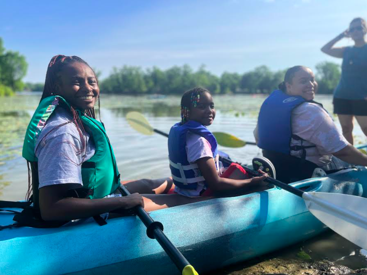Kayla Shannon and Keonia Thompson with a scholar during an FFSC kayaking field trip.