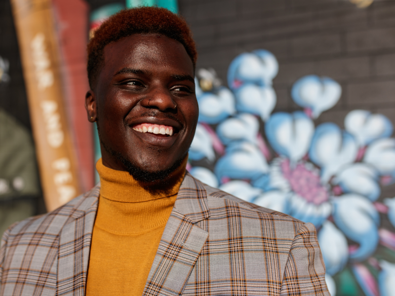Poet, actor, and author Jerimiah Whitehead smiles confidently outside Totem Books in downtown Flint on Nov. 17, 2023.