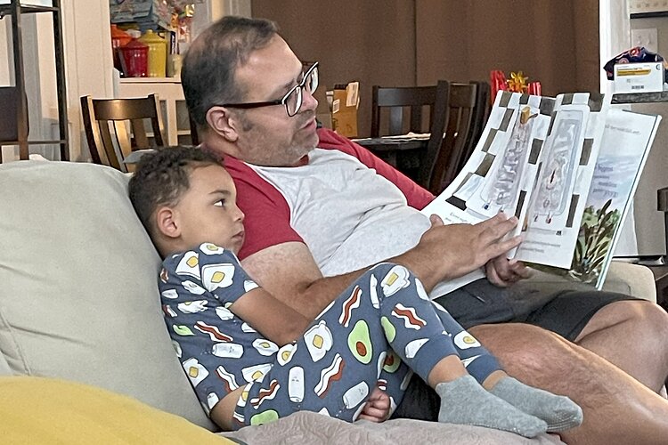 Chad's husband Tony reads to their son Connor.
