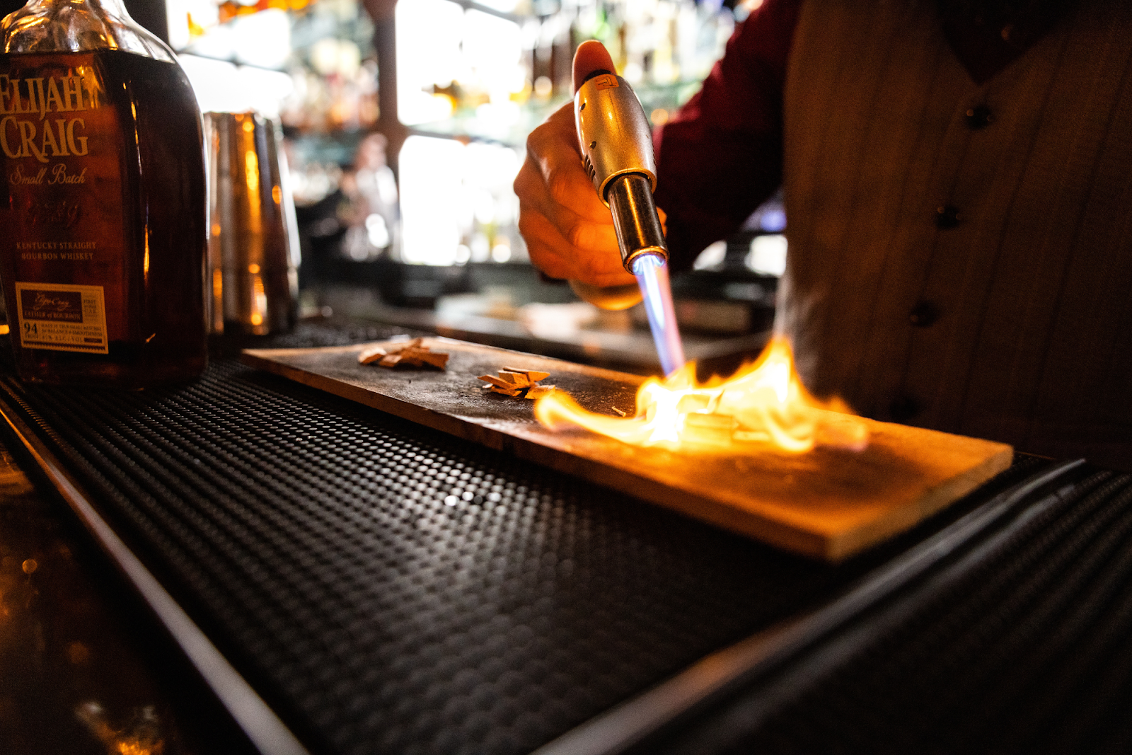 Delgado pictured roasting small pieces of wood in preparation for The X's signature old-fashioned cocktails on Oct. 25, 2023. (Bryce Mata | Flintside.com)