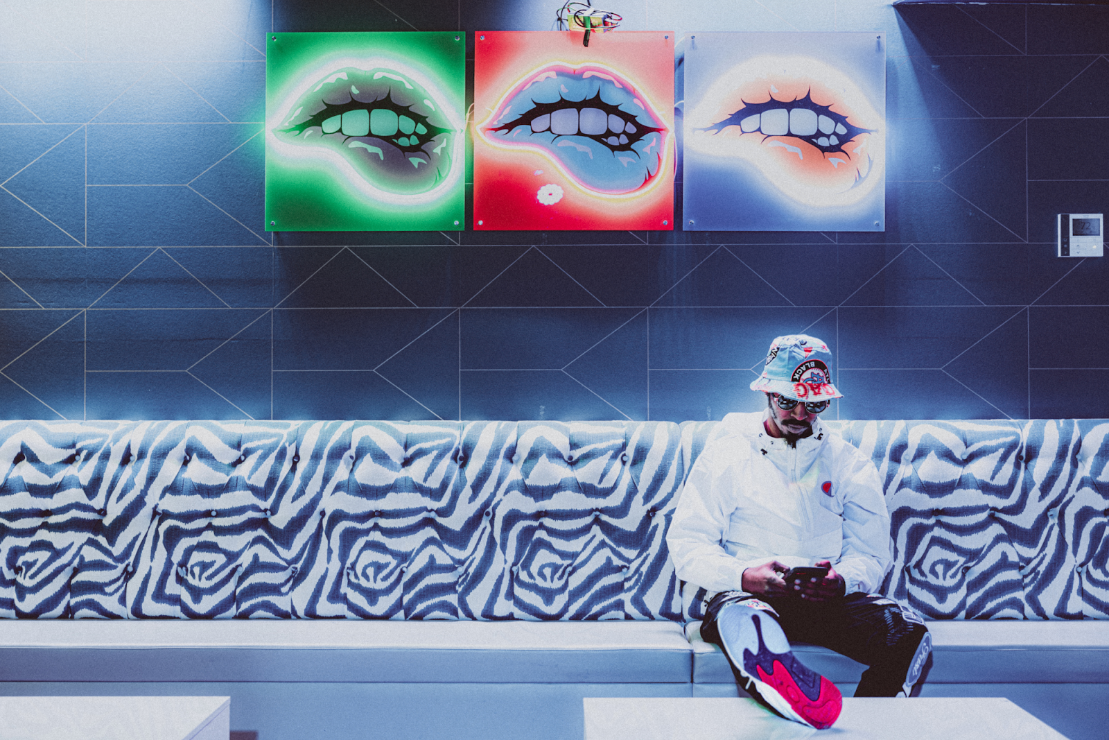 Flint R&B artist Thee Jerne takes a moment to check messages and emails inside Pop Rox in downtown Flint on Oct. 13, 2023. (Bryce Mata | Flintside.com)