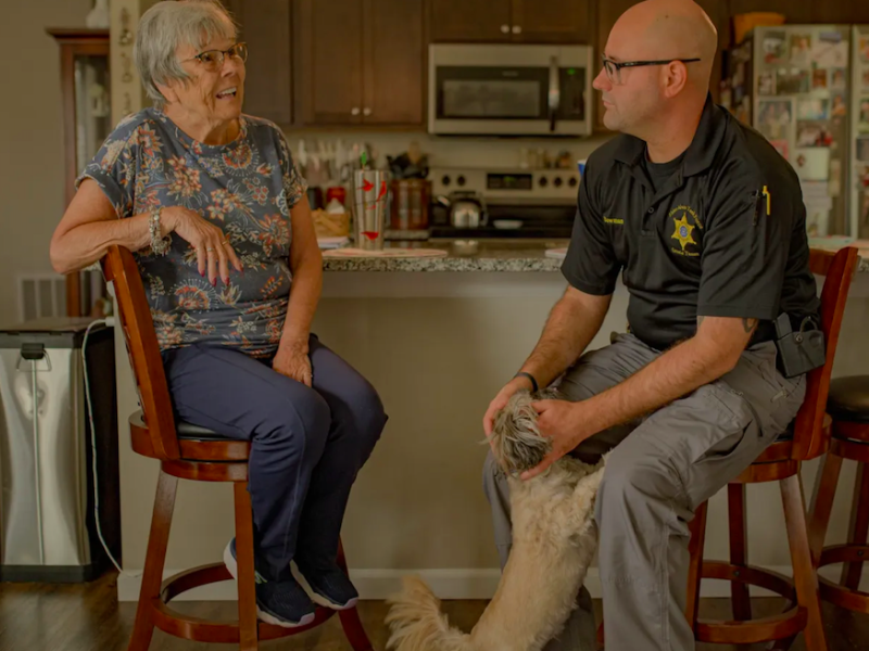 Genesee County Sheriff's Deputy Christian Bowman, of the GRACE Team, visits Pat Kain, a Grand Blanc resident that he helped after she'd been receiving phone calls from an individual posing as a federal agent, at her home on Wednesday, Aug. 30, 2023.