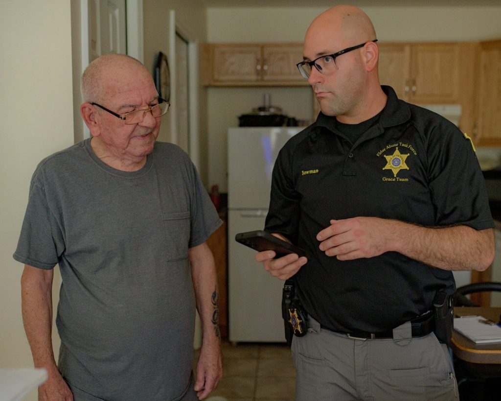 Genesee County Sheriff’s Deputy Christian Bowman (right) visits Flint Township resident Charles Clear (left) at his home on Wednesday, Aug. 30, 2023. Bowman helped Clear get into this apartment earlier this year, he said, after he found him living at a motel on Dort Highway. (Michael Indriolo | Flint Beat)