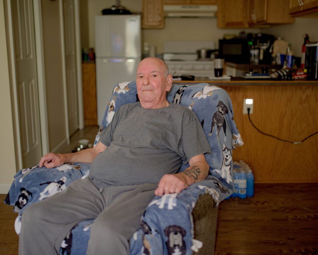 Flint Township resident Charles Clear poses for a portrait in his home on Wednesday, Aug. 30, 2023. Genesee County Sheriff’s Deputy Christian Bowman, of the GRACE Team, helped Clear get into this apartment earlier this year, he said, after he found him living at a motel on Dort Highway. (Michael Indriolo | Flint Beat)