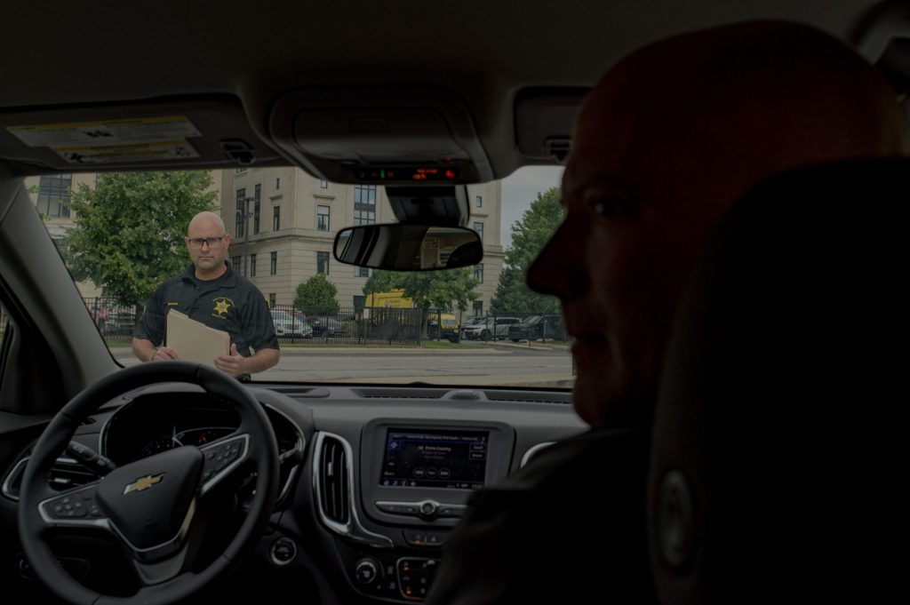 Lieutenant Robert Nicklesen (right) and Deputy Christian Bowman (left) get into their undercover vehicle at the Genesee County Sheriff’s Office in Downtown Flint, Mich. on Wednesday, Aug. 30, 2023. (Michael Indriolo | Flint Beat)