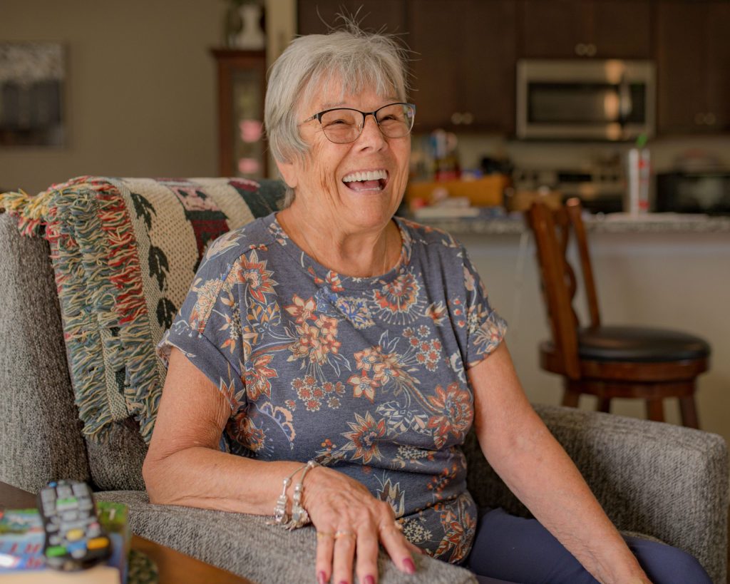 Grand Blanc resident Pat Kain laughs in her home on Wednesday, Aug. 30, 2023. (Michael Indriolo | Flint Beat)

