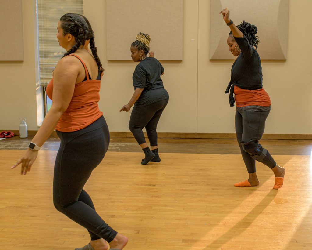 Instructor Tara Holliman (right) and her students Lucy Davis (center) and Dezi Snowden (left) practice the ball change dance move during the Motion in Harmony inclusive dance class at the Flint Institute of Performing Arts on Tuesday, Sept. 19, 2023. (Michael Indriolo | Flint Beat)