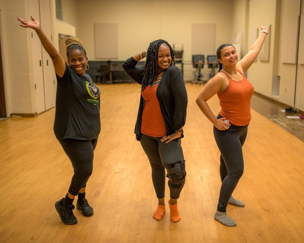 Instructor Tara Holliman (center) and her students Lucy Davis (left) and Dezi Snowden (right) pose for a picture during the Motion in Harmony inclusive dance class at the Flint Institute of Performing Arts on Tuesday, Sept. 19, 2023. (Michael Indriolo | Flint Beat)