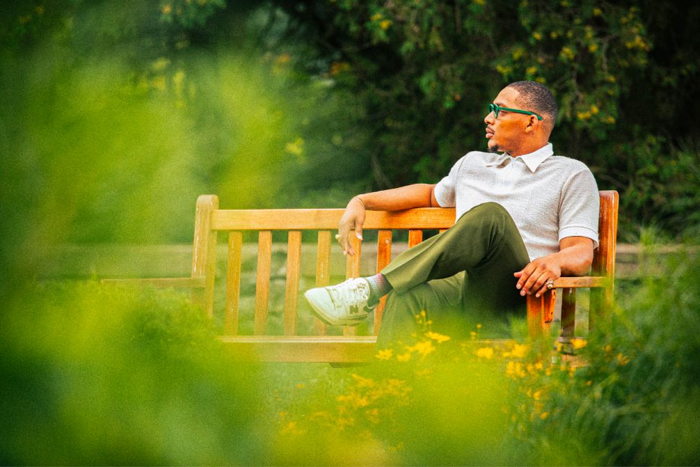 "In real life, I'm laid back. I like to hang out and chill," says music artist This Life. We Lead. seated on a bench at Cranbrook House & Gardens in Bloomfield Hills on August 7, 2023. (Bryce Mata | Flintside)
