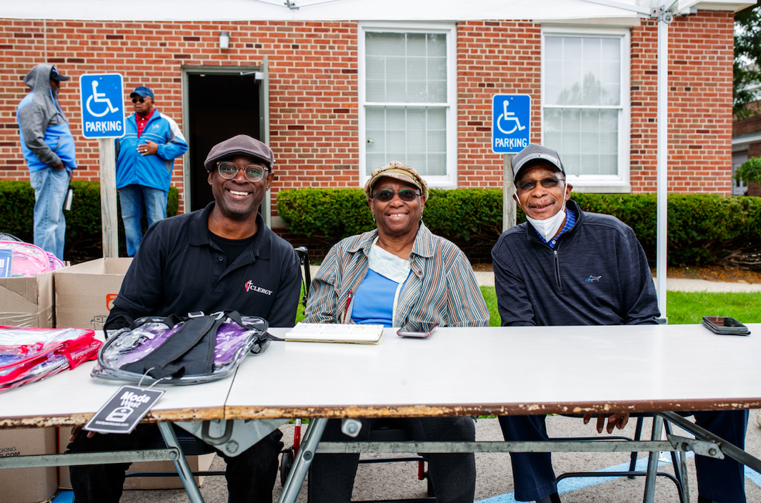 (From left to right) Pastor Hopkins, Rosya Anderson, and Charlie Phillips run the tent with free back pack and school supplies during the ‘Back to School Rally’ at Bethel United Methodist Church in Flint on Saturday, Sept. 9, 2023. (Jenifer Veloso | Flintside.com)