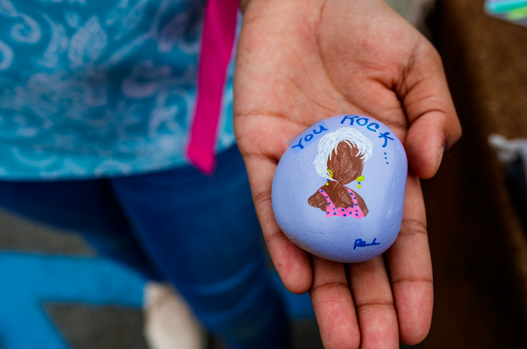 Zariyah poses with a handprinted stone from Sista Girl Greeting Cards that states, “You rock!’ during the ‘Back to School Rally’ at Bethel United Methodist Church in Flint on Saturday, Sept. 9, 2023. (Jenifer Veloso | Flintside.com)