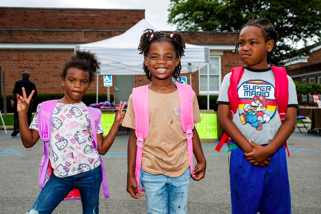 Three children pose with their brand new backpacks during the ‘Back to School Rally’ at Bethel United Methodist Church in Flint on Saturday, Sept. 9, 2023. (Jenifer Veloso | Flintside.com)