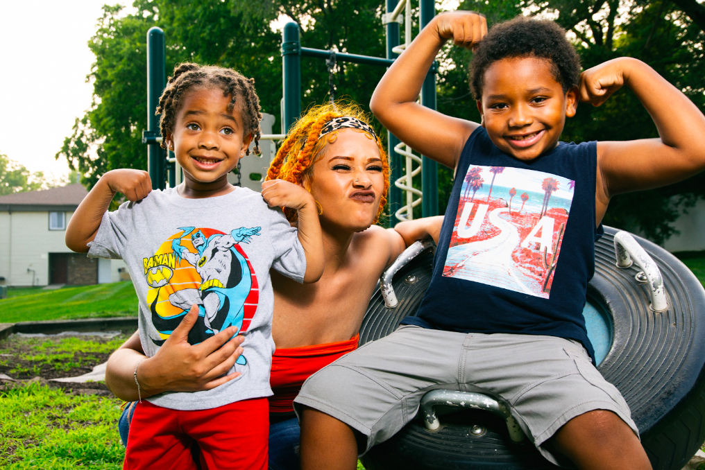 Taylor Tatum smiles on the playground with her two sons, Tamir, 6, and Taylyon, 3, on July 30, 2023. (Bryce Mata | Flintside)
