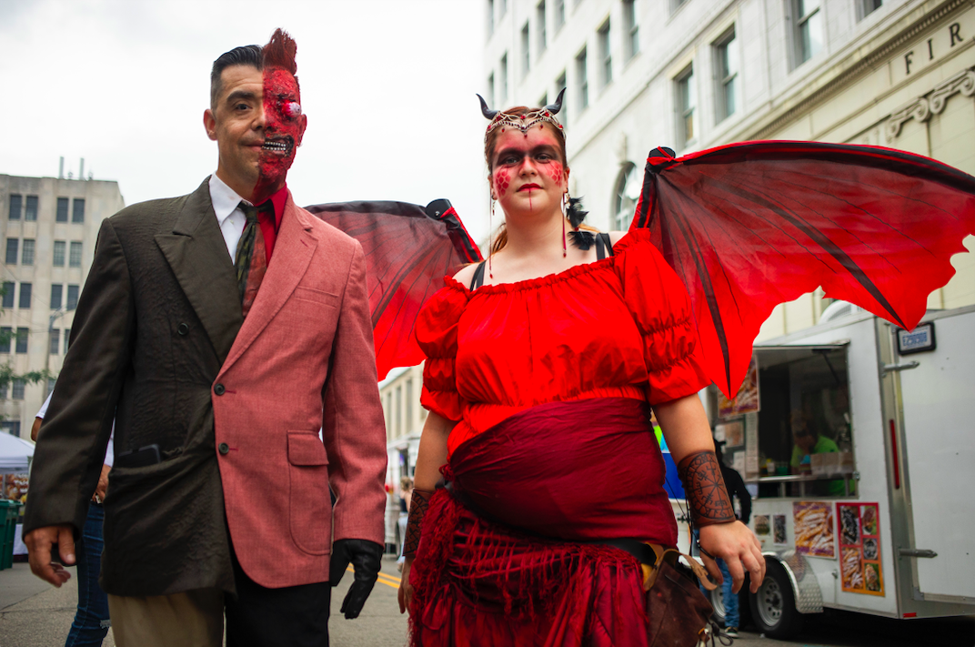 Eric the Cosplay Guy, left, and Lorna Lewis, right, dress in costume to promote Fett's Toy Depot as hundreds of people gather in downtown Flint's Buckham Alley for Alley Fest on Saturday, July 8, 2023. (Katy Kildee | Flintside)