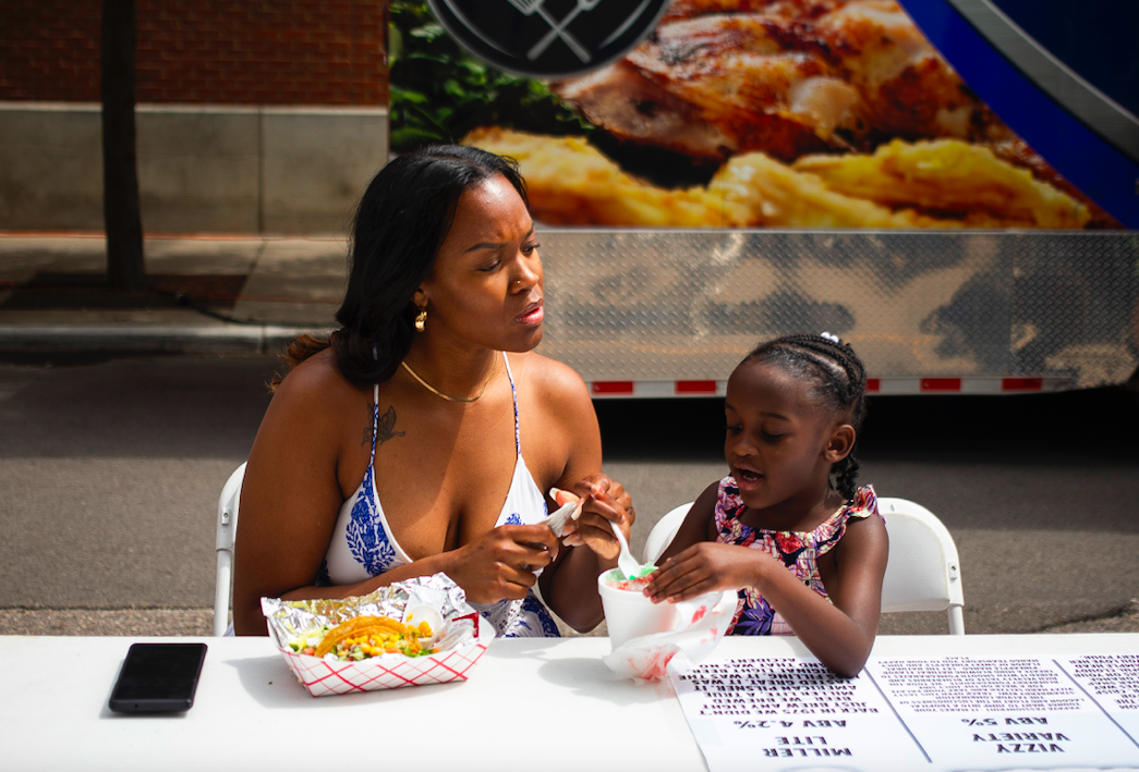 Hundreds of people gather in downtown Flint's Buckham Alley for Alley Fest, an annual event hosted by nonprofit Friends of the Alley featuring live music, food, and vendors, on Saturday, July 8, 2023. (Katy Kildee | Flintside)