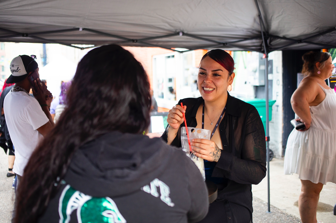 Andrea Guerrero of Flint, right, chats with a friend as hundreds of people gather in downtown Flint's Buckham Alley for Alley Fest on Saturday, July 8, 2023. (Katy Kildee | Flintside)

