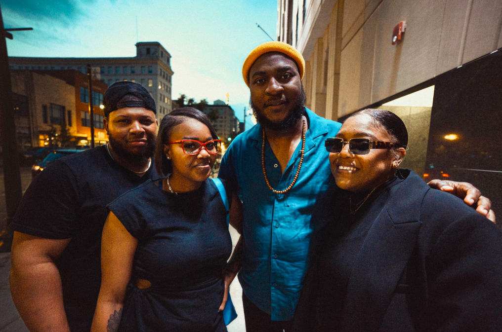 Fellow bandmates (left to right) Dominique Mitchell, Natasha Griffin, Feimstro, and Jarielle Nettles pose outside Blackstone's Smokehouse after the opening night of their downtown tour on June 10, 2023. (Bryce Mata | Flintside)