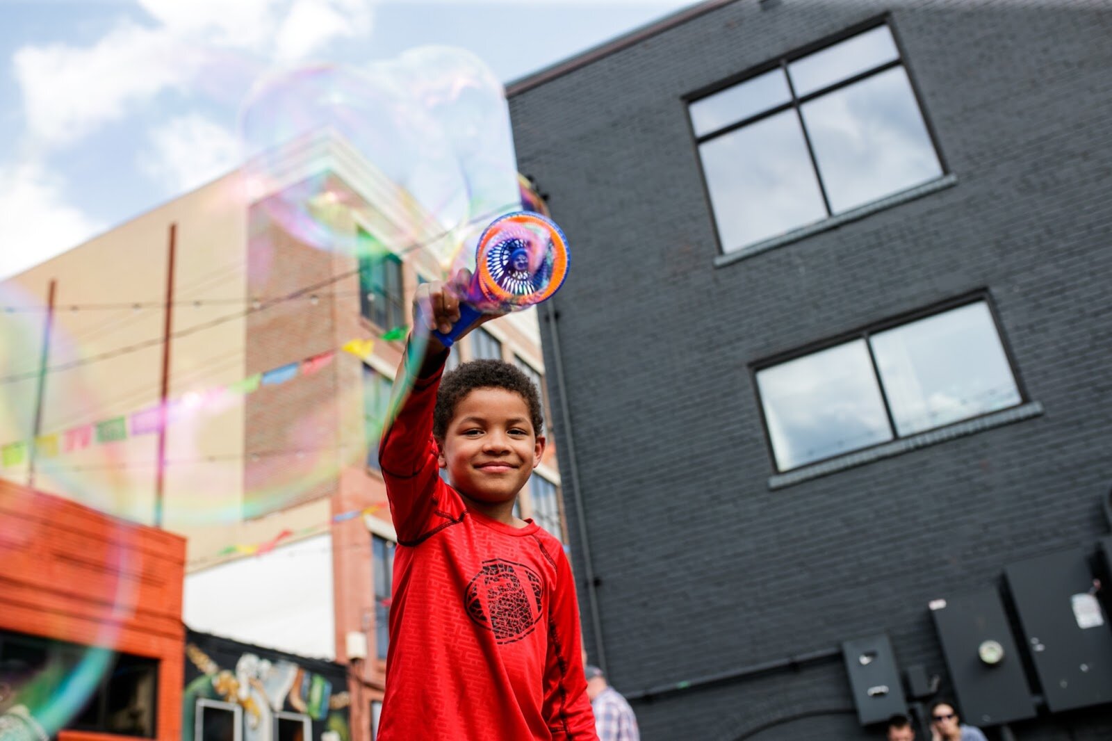 Matteo Kidd, 6, plays with bubbles during the Latinx Technology & Community Center’s Cinco de Mayo celebration on Friday, May 5, 2023, in Buckham Alley in downtown Flint. (Jenifer Veloso | Flintside)
