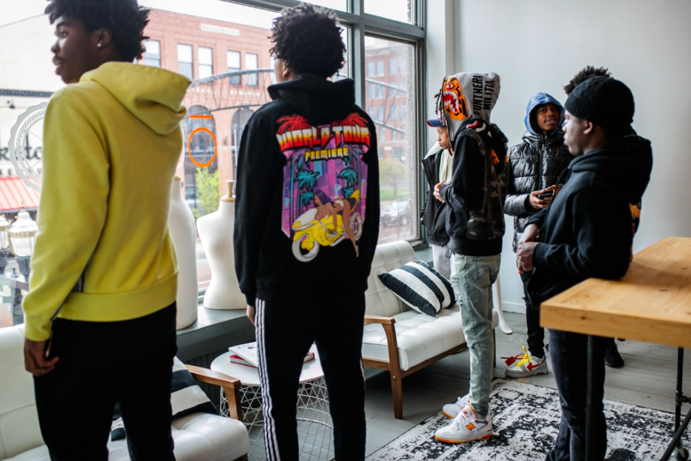 A few young men from the Boys & Girls Club smile and look out of the second-story window on Tuesday, May 2, 2023, at BAU-HOUSE in downtown Flint. (Jenifer Veloso | Flintside)