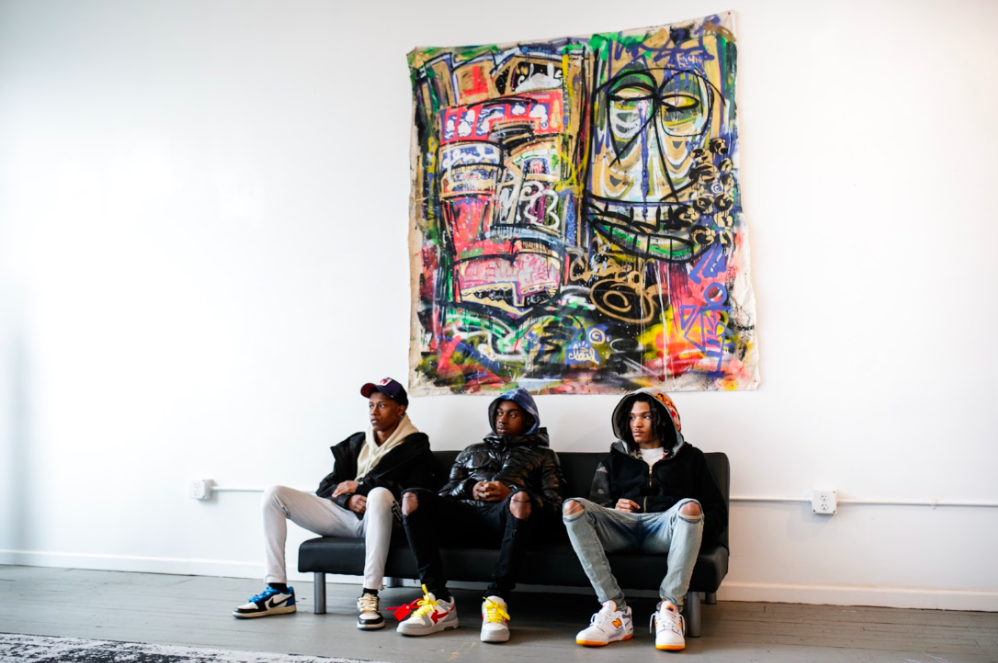 Three young men from the Boys & Girls Club sit and listen to co-owner Allen as he shares his personal journey on Tuesday, May 2, 2023, at BAU-HOUSE in downtown Flint. (Jenifer Veloso | Flintside)