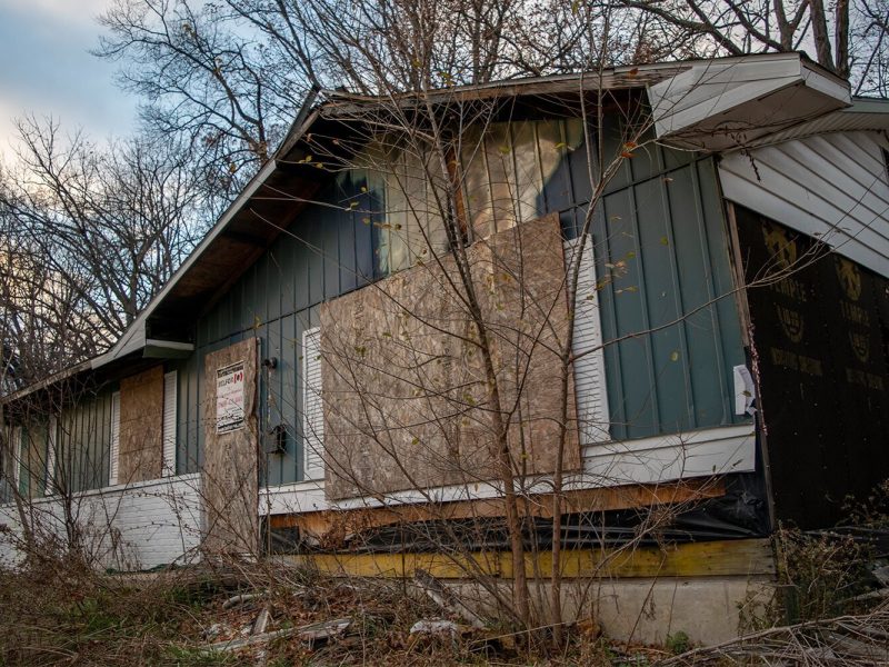 An abandoned home on Home Ave. in Flint sits vacant with the windows and front door boarded up.