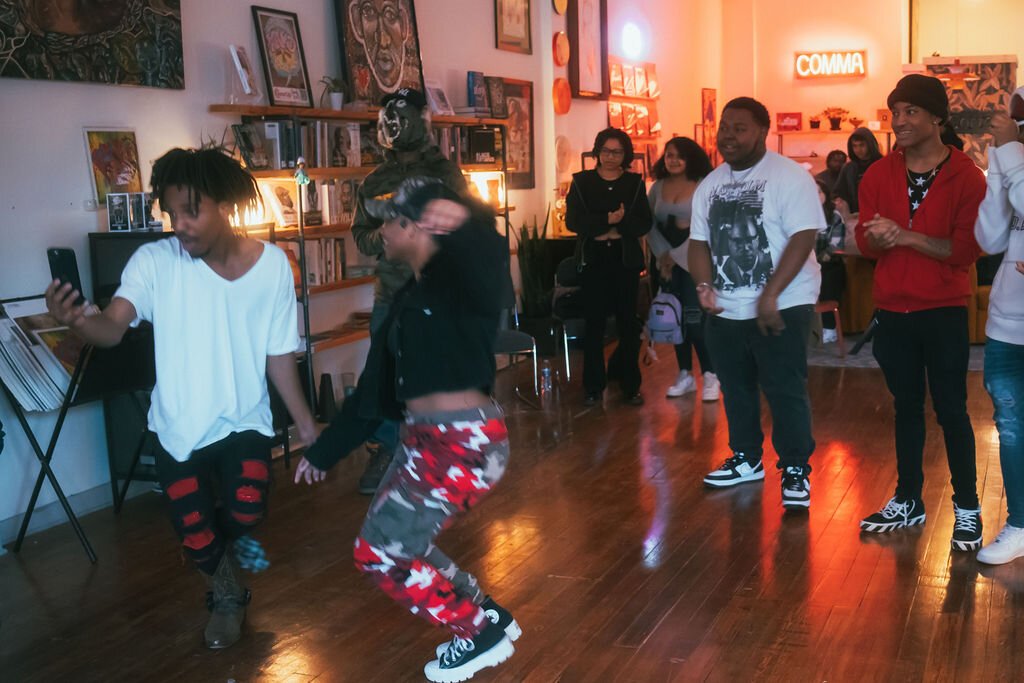 Local artists laugh and dance during Open Mic Night at Comma Bookstore & Social Hub on Friday, April 7, 2023. (Mike Powell | Flintside)