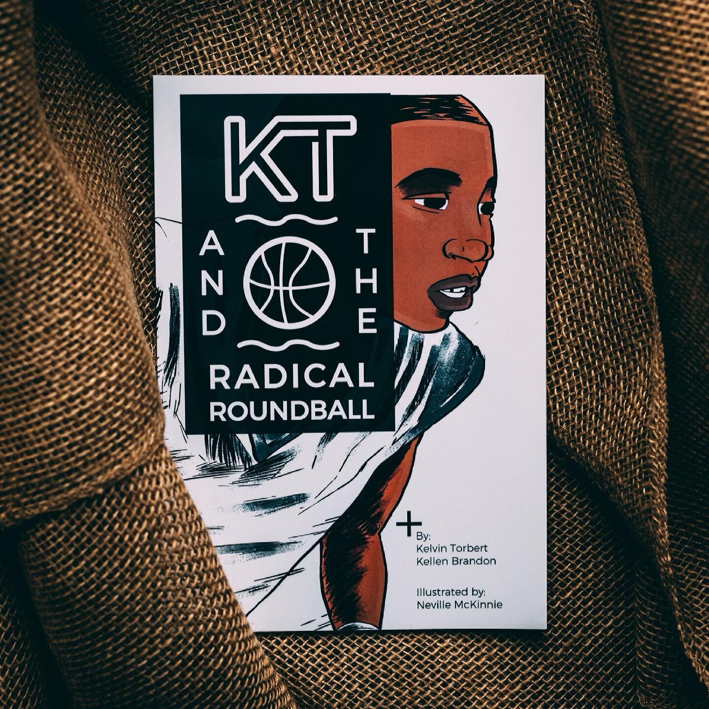 A copy of the book “KT and the Radical Roundball” by Kellen Brandon and Kelvin Torbert. 