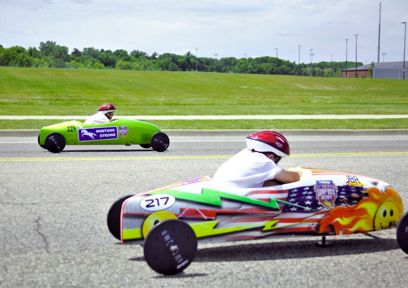 Young participants racing to the finish line at the 2nd annual Flint Soap Box Derby Race that took place in June 2022.