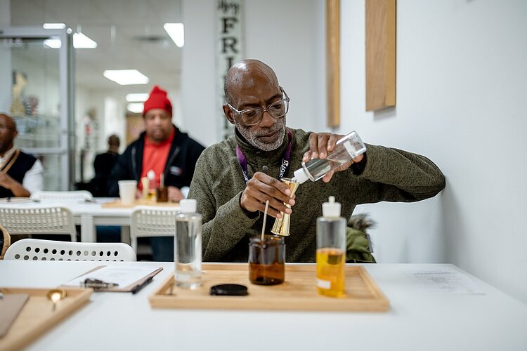 Food and Friendship Connections participant Waymond Barks creates a candle during a social outing.
