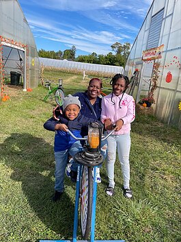 DPSCD families make their own pumpkin smoothies on a bike-powered blender at Drew Farms Harvest Fest. 