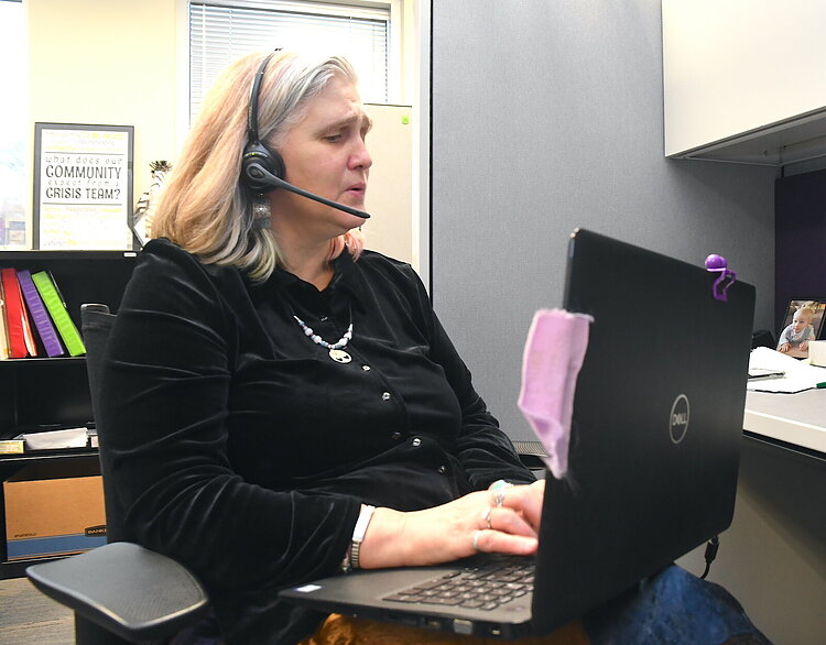 Valerie Lamper, on the phone, is a clinical social worker at Summit Pointe’s First Step Urgent Care.
