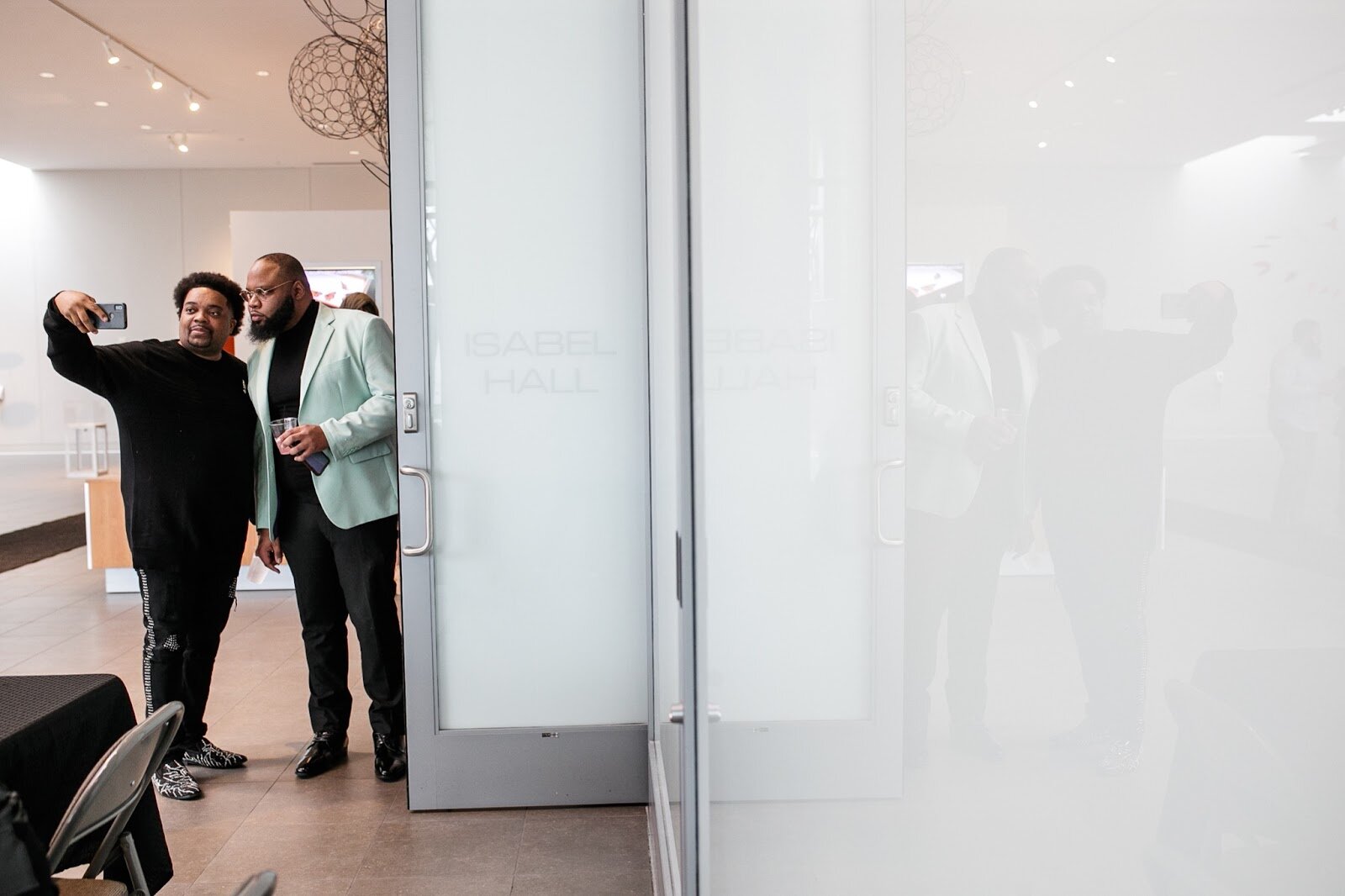 Brandon Corder poses for pictures with a guest during the third annual Toast Awards, hosted by Beats x Beers, at the Flint Institute of Arts on Saturday, Dec. 17, 2022. (Jenifer Veloso | Flintside)
