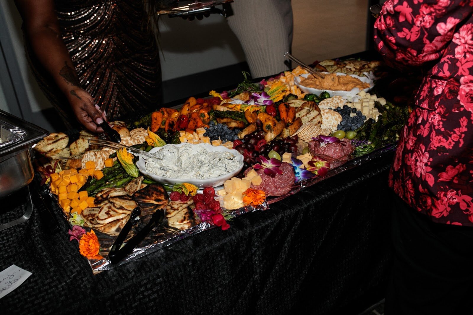 Toast guests take food from the buffet line provided by Chef K Smith, Chef Brandon Dewayne, and Chef Quay during the third annual Toast Awards, hosted by Beats x Beers, at the Flint Institute of Arts on Saturday, Dec. 17, 2022. (Jenifer Veloso | Flintside)

