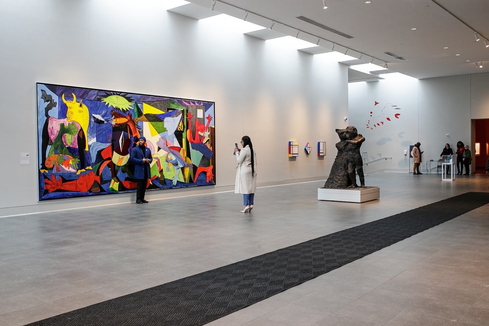 Toast guests pose for a picture in front of a large handing painting before the third annual Toast Awards, hosted by Beats x Beers, at the Flint Institute of Arts on Saturday, Dec. 17, 2022. (Jenifer Veloso | Flintside)
