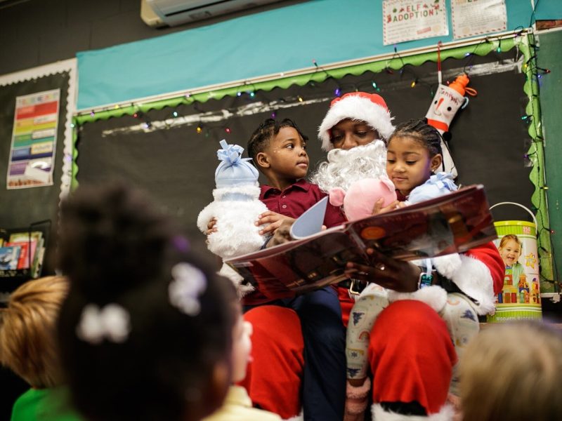 Genesee County Sheriff Deputy Blanding reads The Polar Express to kindergarteners during Freeman Elementary’s holiday celebration of literacy and reading comprehension on Friday, Dec. 16, 2022. (Jenifer Veloso | Flintside)