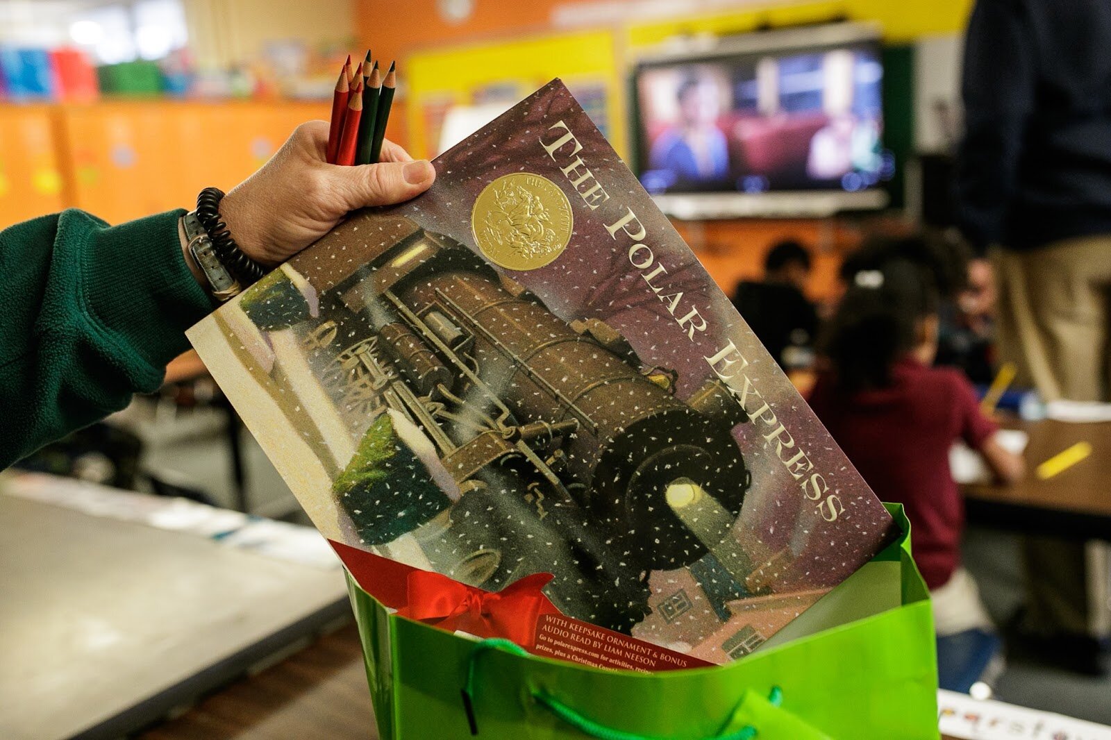 First Grade teacher Mrs. Sandra Baird shows a new copy of the Polar Express inside of each student's Christmas gift bag during Freeman Elementary’s holiday celebration of literacy and reading comprehension on Friday, Dec. 16, 2022. (Jenifer Veloso | Flintside)
